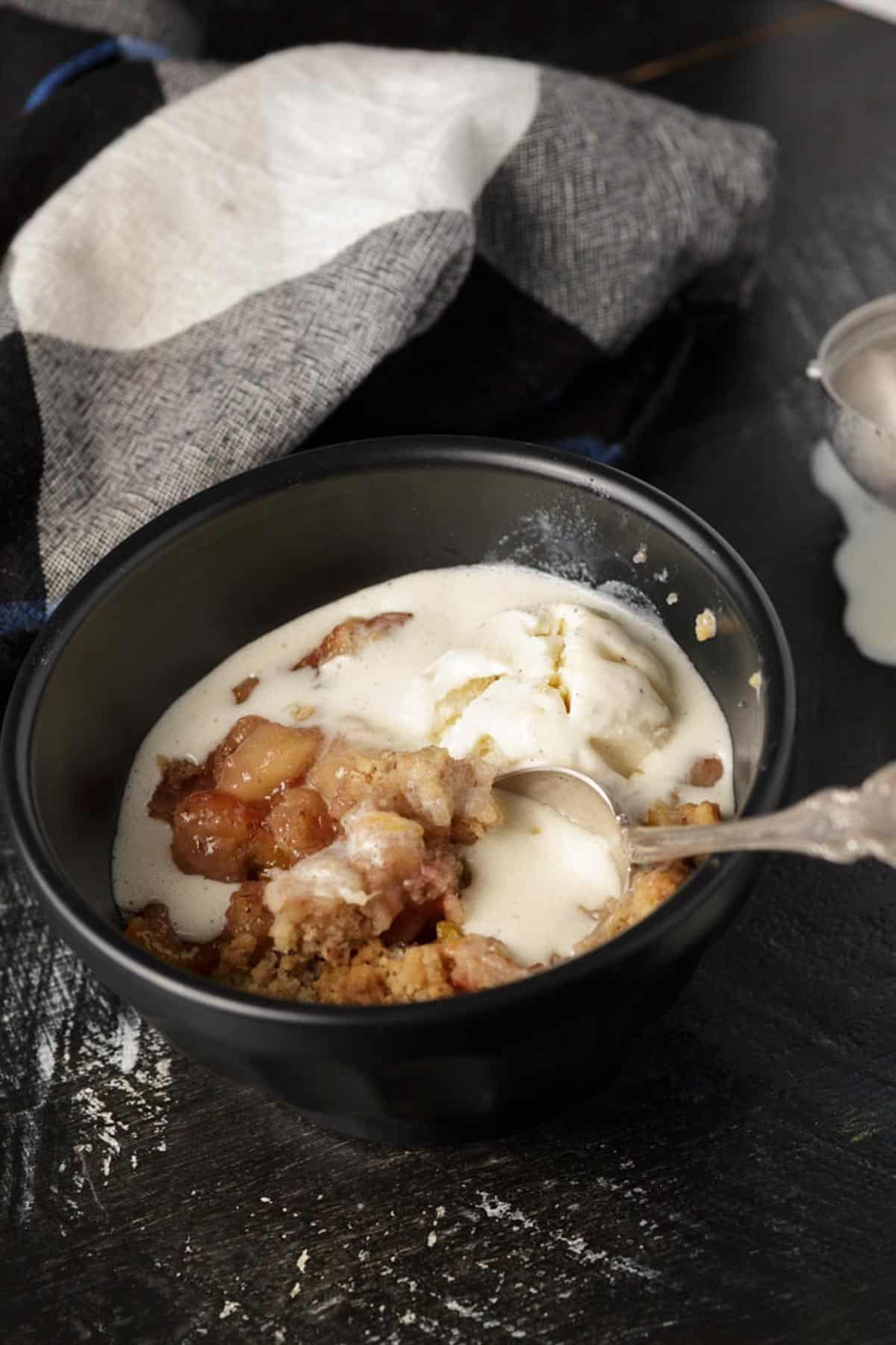 A ramekin filled with Southern blueberry cobbler with a spoon
