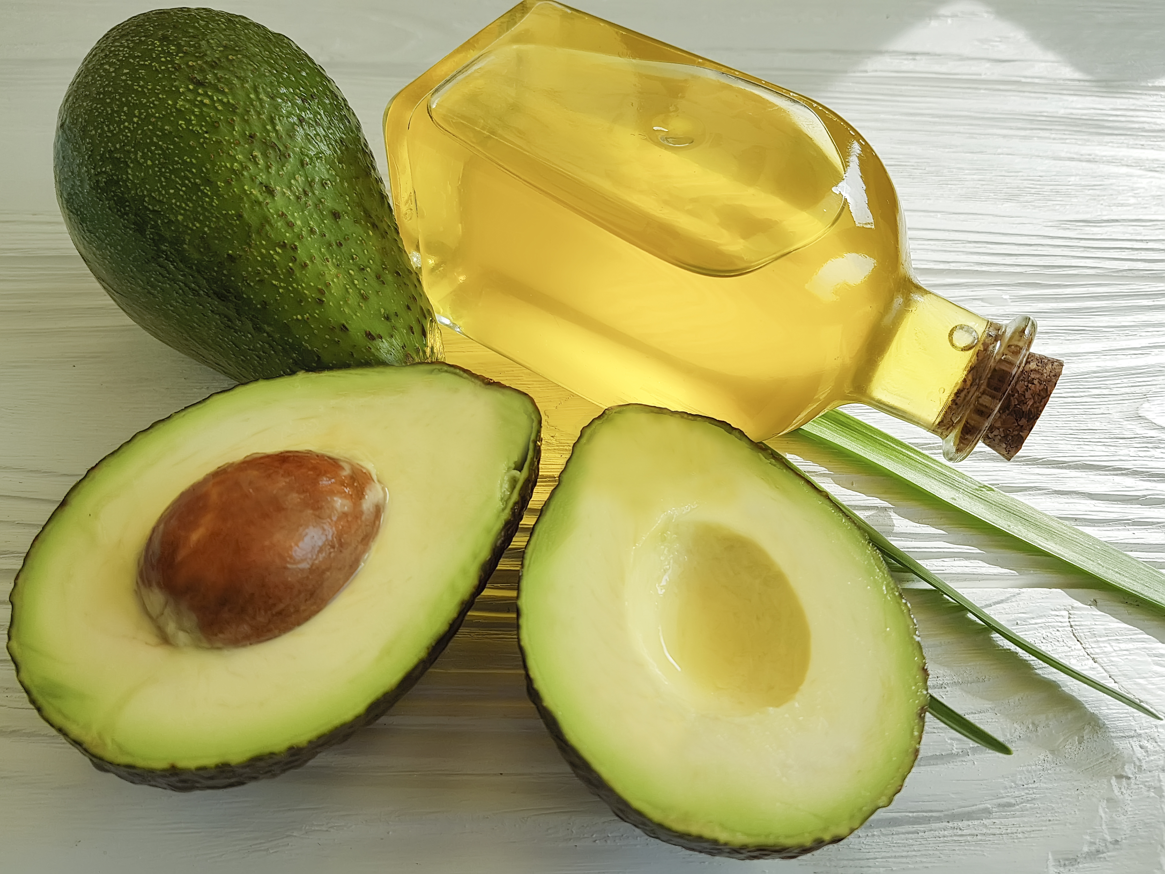 avocado oil on white wooden background