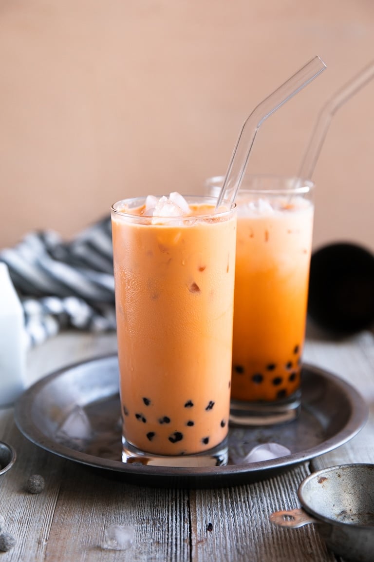 Two glasses filled with ice cold thai tea boba.