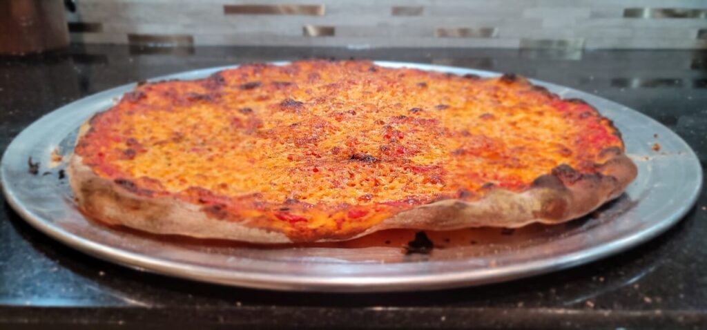 A New Haven style pizza with sauce, cheese, and a thin and crispy crust