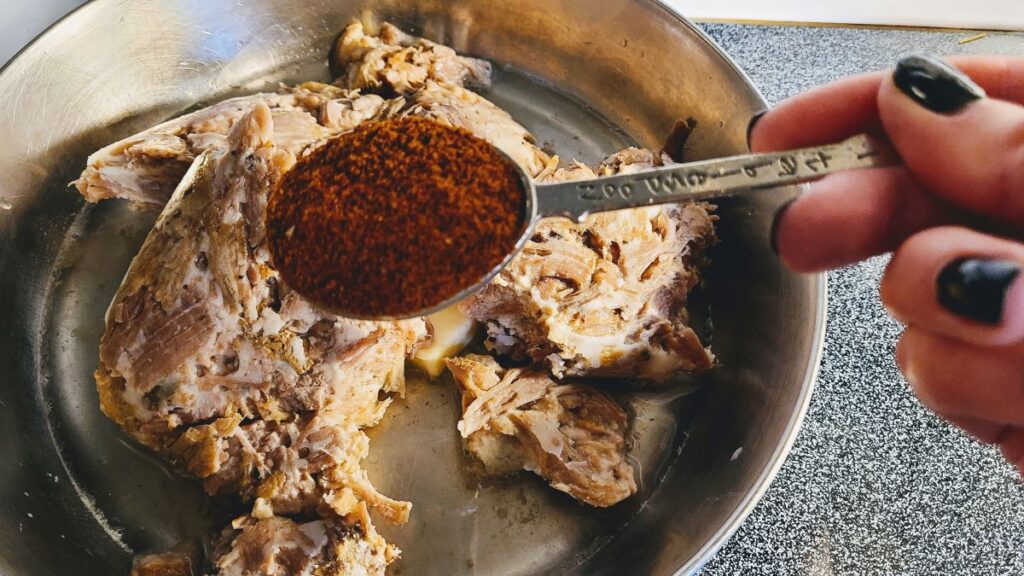seasoning pulled pork in a pan
