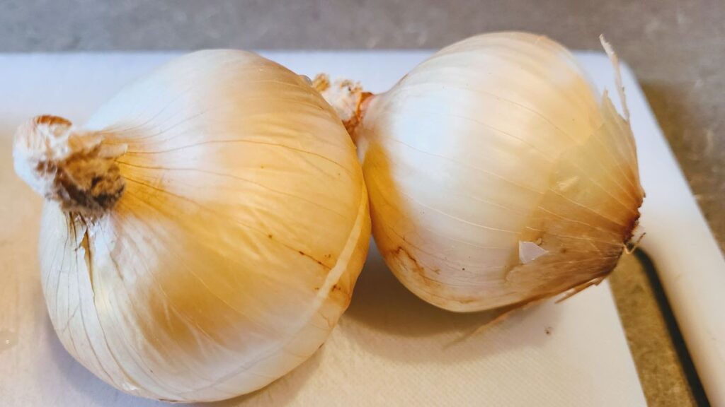 2 onions on a white cutting board