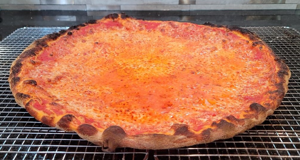 A homemade New Haven style pizza topped with tomato sauce and mozzarella cheese